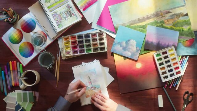 Artist painting with watercolors and brush top view. Art and inspiration, designer. Workspace of creative person using paints, talented human. Leisure and hobby concept.