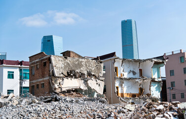 Obraz na płótnie Canvas Contrast of demolished old house and modern skyscraper