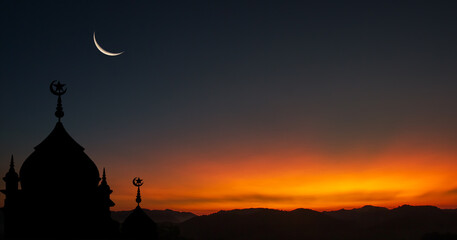 silhouette of a mosque at sunset with crescent moon on dusk sky in the evening religion of Islamic...