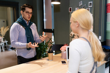 a customer in a flower shop explains to the florist what kind of bouquet he wants to buy for a loved one