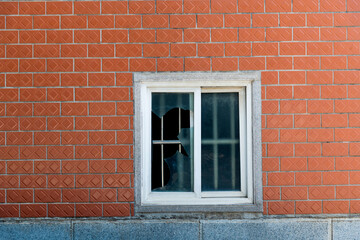Red brick wall with broken glass window