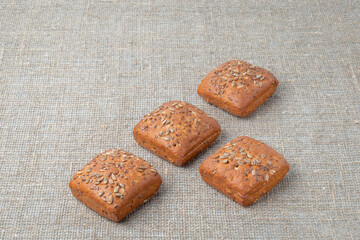 Rye bread with seeds, on the background of burlap