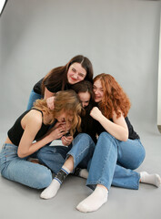 Group of female friends in a studio. Four happy woman hugging together.