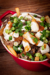 duck confit poutine dish on wood table poutine is a canadian meal made with french fries gravy and cheese curds