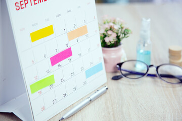 Close up paper note on business desk calendar with office equipment concept of event planner or personal organization reminder and schedule or planning.
