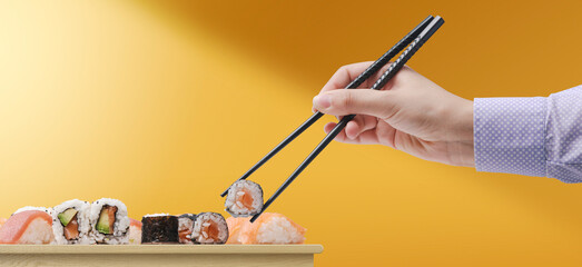 Woman eating sushi using chopsticks