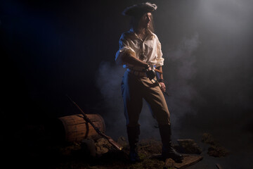 Naklejka premium Pirate filibuster sea robber in suit with gun and saber. Concept photo