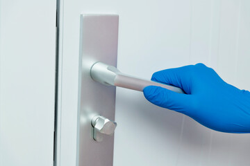 Naklejka premium Woman's hand open the door with glove