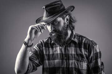 Man unshaven cowboys. American cowboy. Leather Cowboy Hat. Portrait of young man wearing cowboy hat. Cowboys in hat. Handsome bearded macho