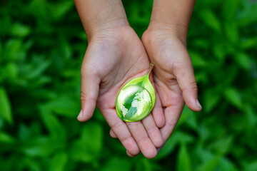 Hand Embracing Green Leaf and Globe, World Earth Day Concept. Green Energy, ESG concept. girlie hand for environmental,