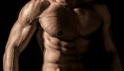 Muscular torso close up. Muscular sexy man with torso. Muscular model sports young man on dark...