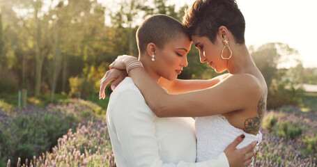 These are two humans who were made for each other. Cropped shot of an affectionate young lesbian couple standing with their arms around each other in a meadow on their wedding day. - obrazy, fototapety, plakaty