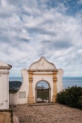 Cemetery entrance at Sant'Antonino in the Balagne region of Corsica with the Mediterranean sea in the distance