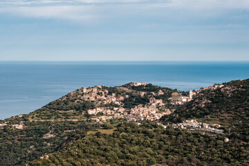 Hilltop village of Corbara in the Balagne region of Corsica with Mediterranean sea in the distance