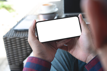 Cell phone blank white screen mockup. Man hands holding, using mobile phone at coffee shop, template for advertisement