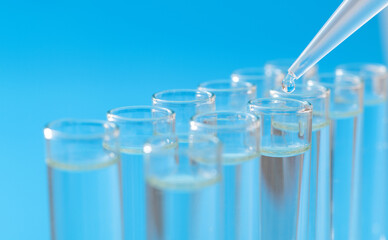 Liquid drop to test tube on blue background