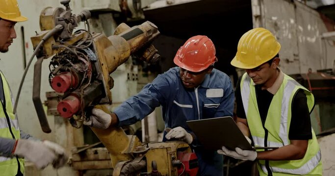Group of machine technicians are profession inspect the electrical equipment in factory. Industrial plant engineers plan machine maintenance. African American workers work with Asian team Blue collar