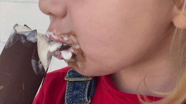 4k. Cute caucasian little girl eating ice cream.