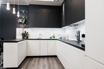 Stylish, corner kitchen with a table in black and white