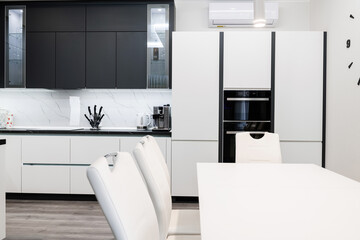Built-in appliances in the kitchen with white and black furniture