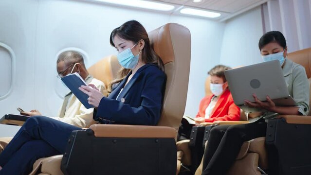 New normal travel after covid-19 pandemic concept.COVID-19 Worried passengers sitting inside airplane wearing KN95 FFP2 protective mask.passengers wearing face mask is traveling on airplane.