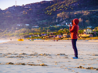 Woman with camera on Tarifa beach, Spain