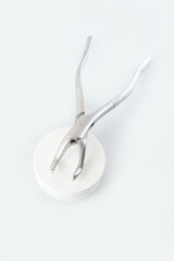 Dental forceps on a light background.Dental instruments.Modern dentistry.Vertical photo.Flat lay.Top view.Copy space.