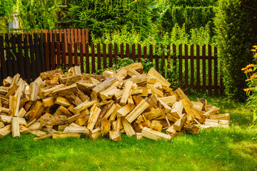 Stack of firewood on green grass.