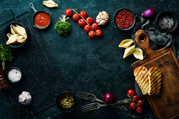 Cooking. Background with vegetables, spices, herbs and kitchen utensils. On a stone background. Top view.