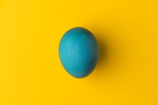 Blue easter egg on yellow background. Colors of the flag of Ukraine. Stop war