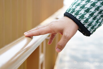 human hand touch Wooden railings at tourist attractions are vulnerable to Covid-19