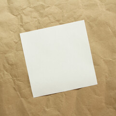Square white empty sheet of paper on a beige craft paper. Concept of analysis, study, attentive work. Stock photo with empty place for your text and design. Square image shape.