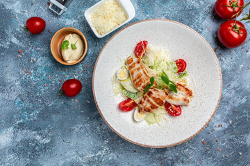 Delicious salad with grilled chicken, cheese, quail eggs and cherry tomatoes, with sauce. balanced food concept, Restaurant menu, dieting, cookbook recipe top view