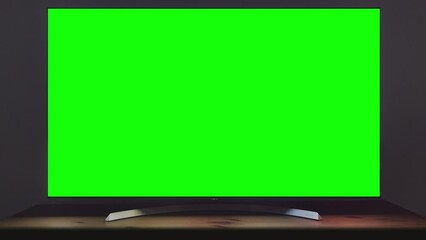 Modern TV turning on via remote control – green screen for screen replacement