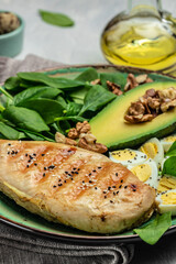 Ketogenic diet. avocado, grilled chicken fillet, quail egg, spinach, walnut, Low carb high fat breakfast, vertical image. top view. place for text