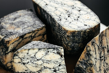 Asiago italian cheese with cuttlefishink on a wooden board. banner, menu, recipe place for text,...