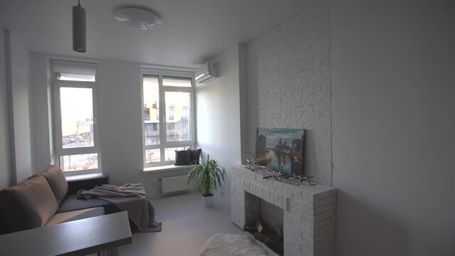 Interior of the modern loft kitchen-studio in the apartment. Room, furniture, sofa near wooden fireplace