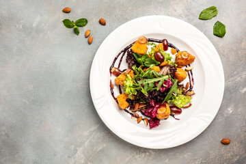 Salad Camembert cheese baked served on lettuce with vegetables, almonds and berry sauce. banner, menu, recipe place for text, top view