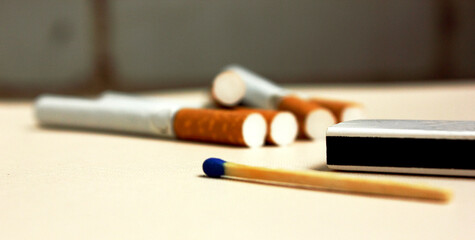 Cigarette and matches on a white background. Yellow filter. Harm to health. It is a bad habit. The vision of a world without tobacco, tobacco and lung health. Lung cancer. Copy space for text.