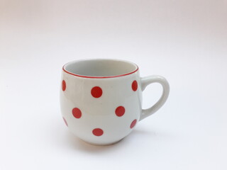 Vintage porcelain cup with red dots isolated