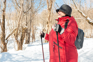 Nordic walking. Elderly woman walks in nature.