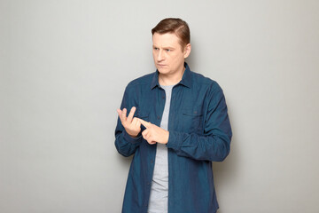 Portrait of serious man making list of something with fingers