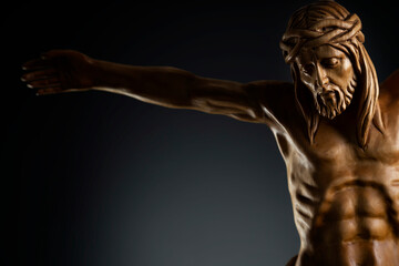 Fototapeta na wymiar Religion theme - Jesus Christ. Cruciefied Jesus figure isolated on rustic dark background.