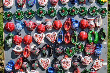 Group of colourful hand painted mixed magnets and suvenirs displayed for sale at a traditional...