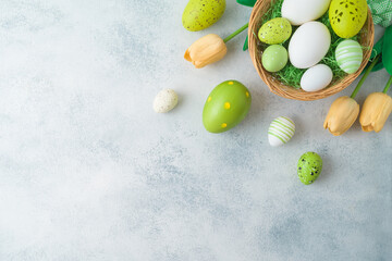 Easter holiday background with Easter eggs in basket and tulip flowers decor. Top view, flat lay