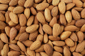 Background of big raw peeled almonds situated arbitrarily