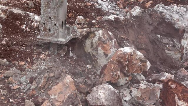Kas, Turkey - 25thth of February 2022: 4K Zoom out Excavator drilling rocky ground
