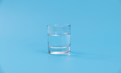 Glass of water on blue background