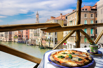 Italian pizza Margarita served on terrace overlooking to Venetian canal, Venice, Italy