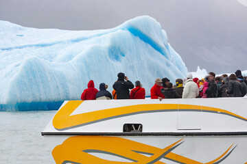 Escursione in barca  di un gruppo di turisti per ammirare un iceberg in Patagonia 